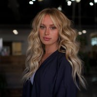 Close-up of a model with soft, wavy blonde hair after a seamless hand-tied extension installation using The Standard Hair Extensions at The Standard Salon in San Luis Obispo.